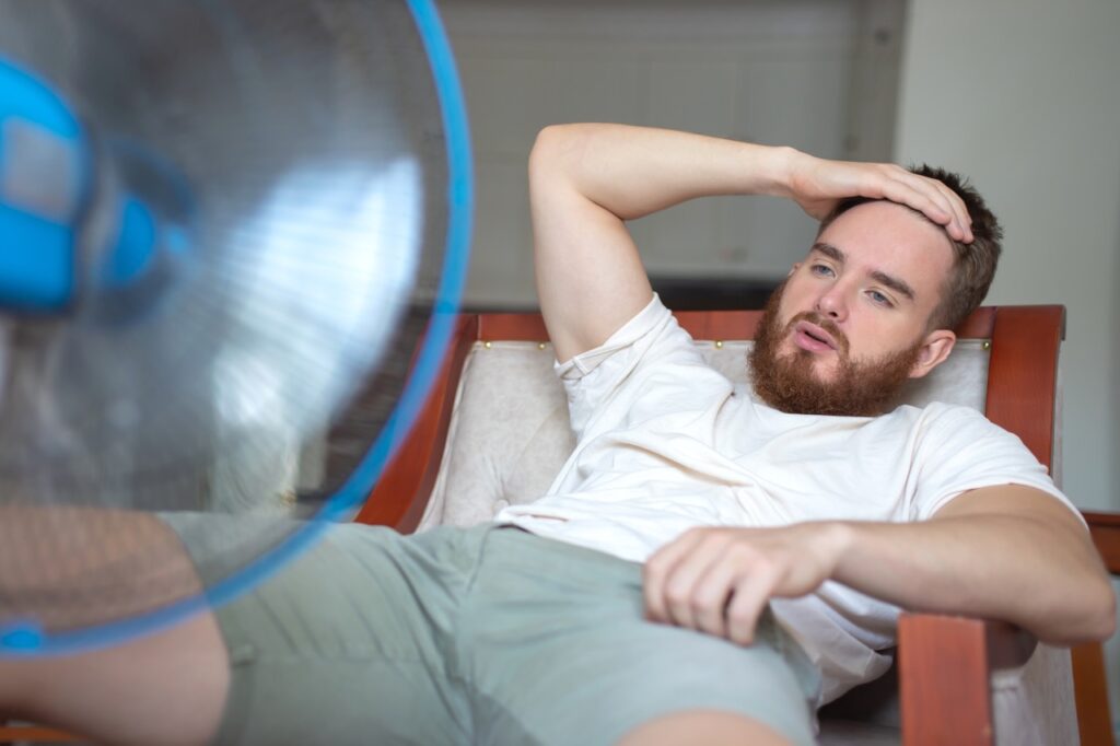 Man sitting in front of fan