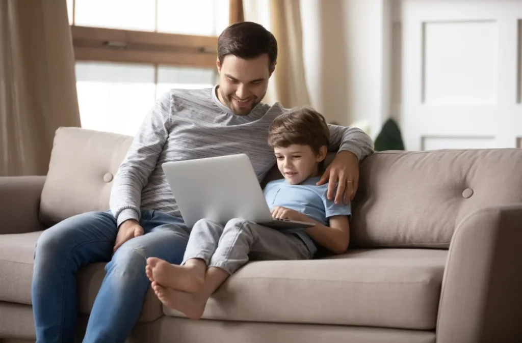 Father and Son sitting on couch, running their air conditioner in Bannockburn.